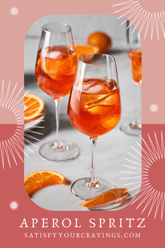 Glass of Aperol Spritz cocktail with orange slice garnish on a wooden table.