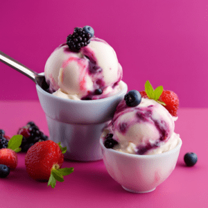 Two bowls of mixed berry frozen yogurt topped with fresh strawberries, blackberries, and blueberries on a pink background.