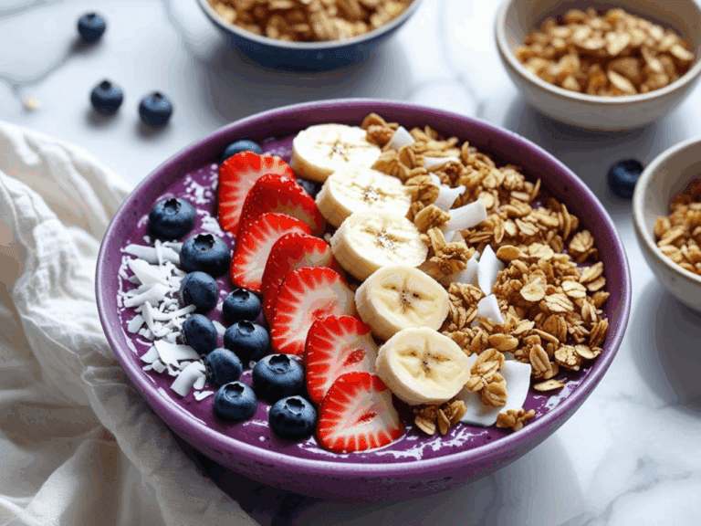 Acai bowl with neatly arranged blueberries, strawberries, bananas, and granola