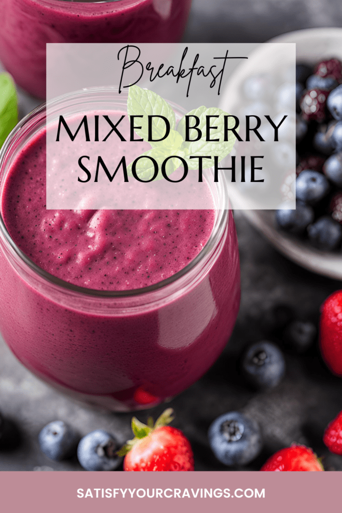 Mixed berry smoothie in a glass with a mint leaf garnish, surrounded by fresh blueberries and strawberries.