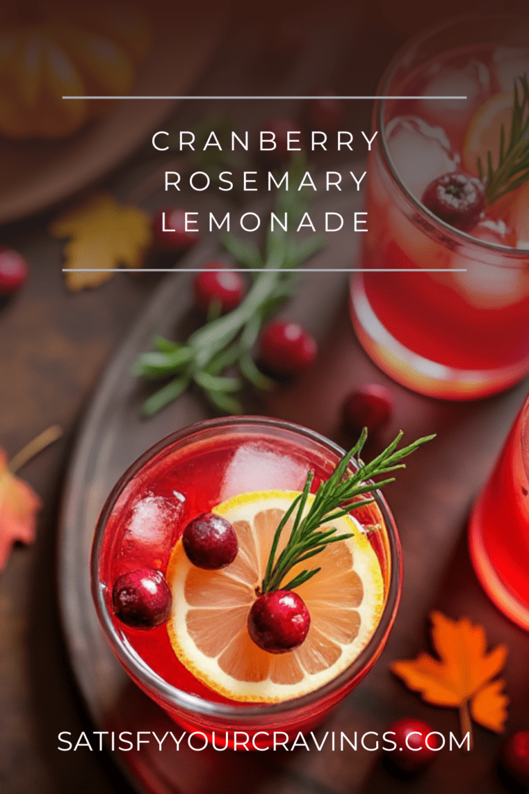 A close-up of cranberry rosemary lemonade garnished with lemon slices, cranberries, and rosemary, with the text "Cranberry Rosemary Lemonade" and the website name "satisfyyourcravings.com"