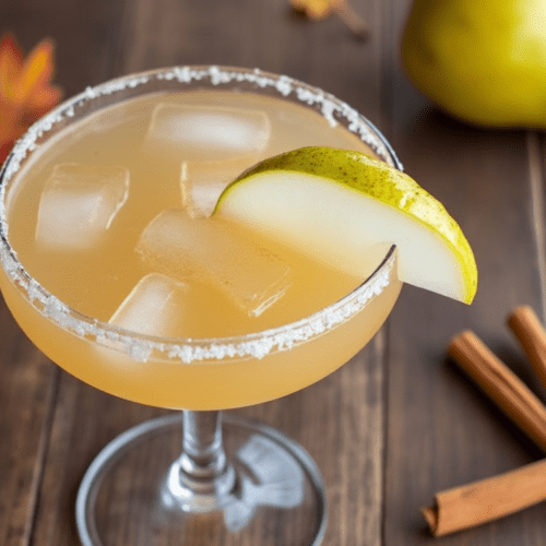 Classic margarita glass filled with Autumn Pear Margarita garnished with pear slice and a salted rim.